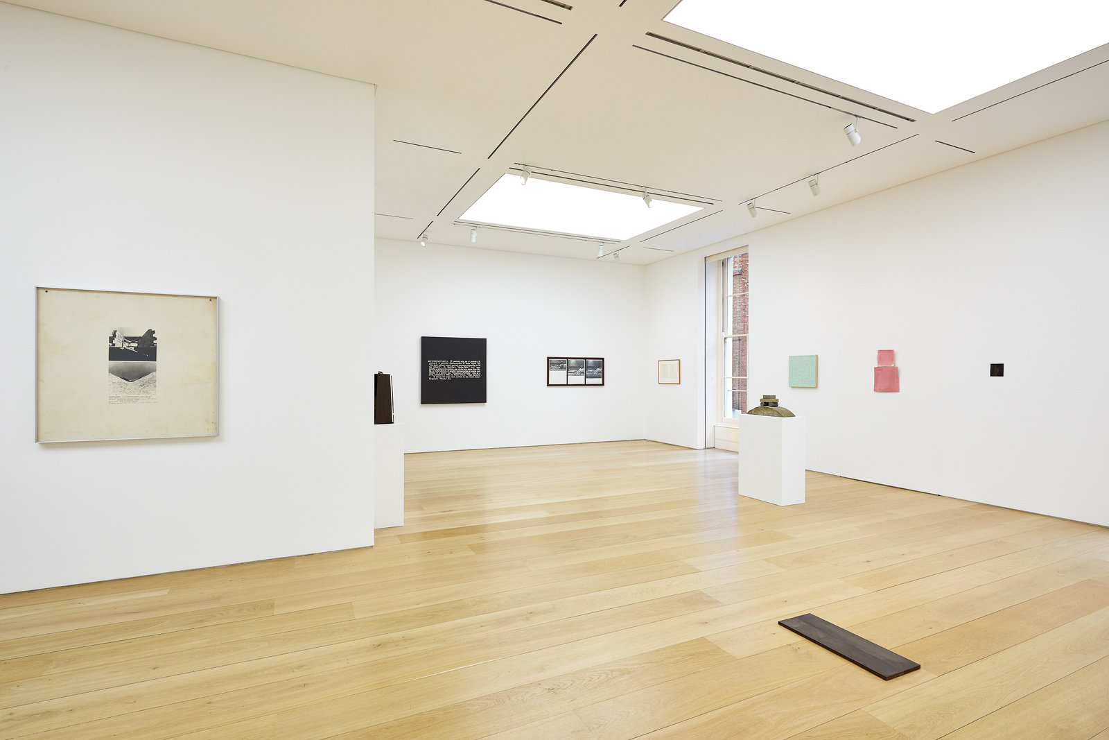 An installation view of works hung on the wall, sculptures on pedestals and floor works. 
