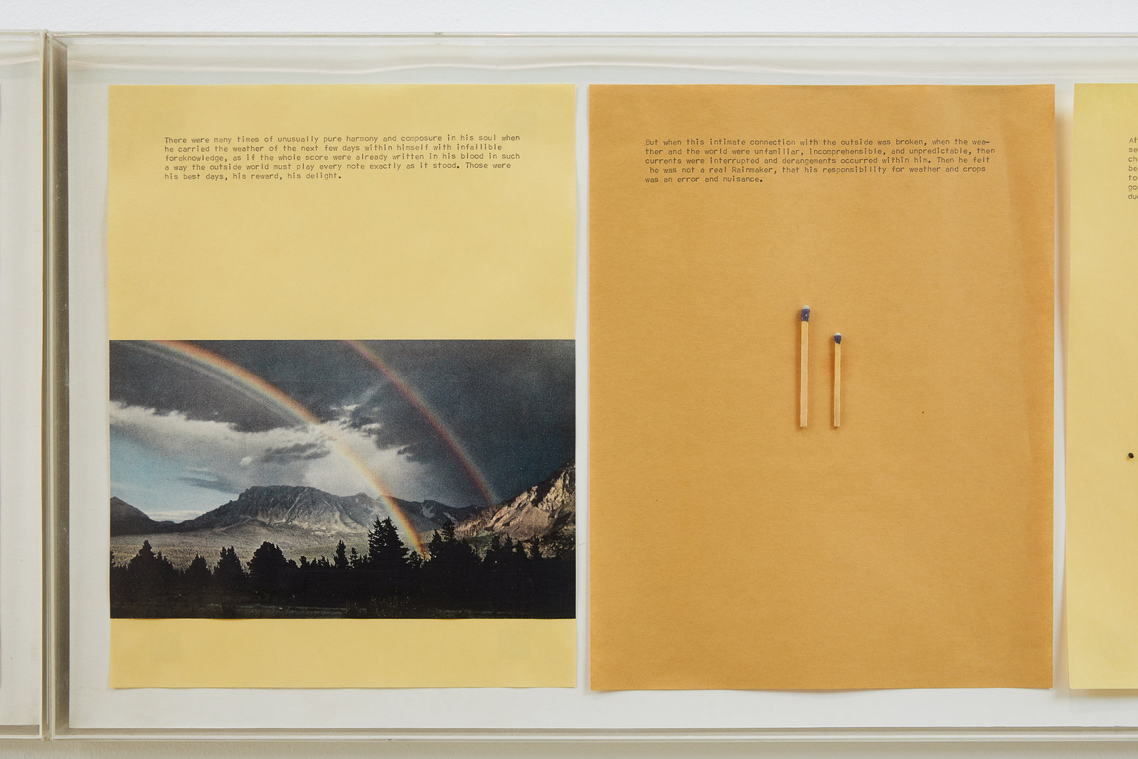 A detail of a mixed media piece by Alexis Smith. Two pieces of yellow paper are side by side. One has an image of a mountainous landscape with two rainbows below several lines of text. The second is a slightly darker yellow with two different size matches below several lines of text. 