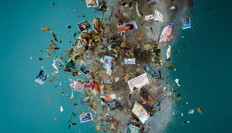 Image of detritus and confetti in explosion, blue background. 