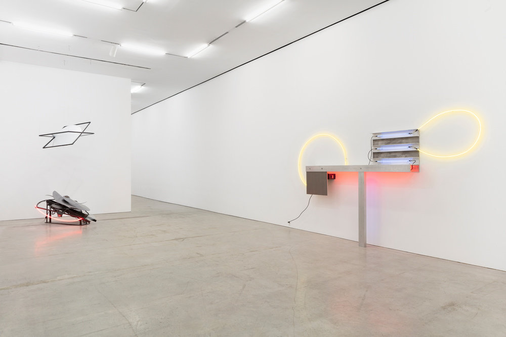 An installation view of a neon and aluminum Keith Sonnier sculpture and a kinetic and neon sculpture by Alice Aycock. 