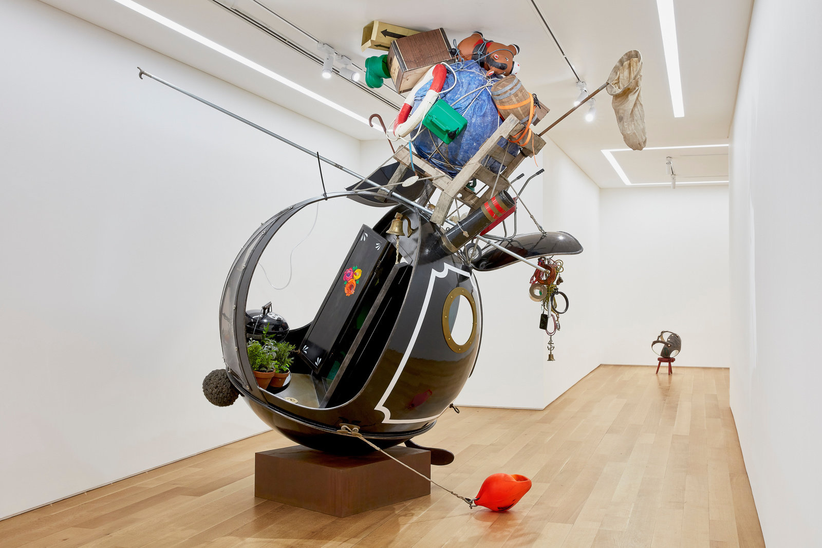 A floor to ceiling spherical sculpture made of steel, glass, vinyl, enamel and found objects by Lars Fisk. 