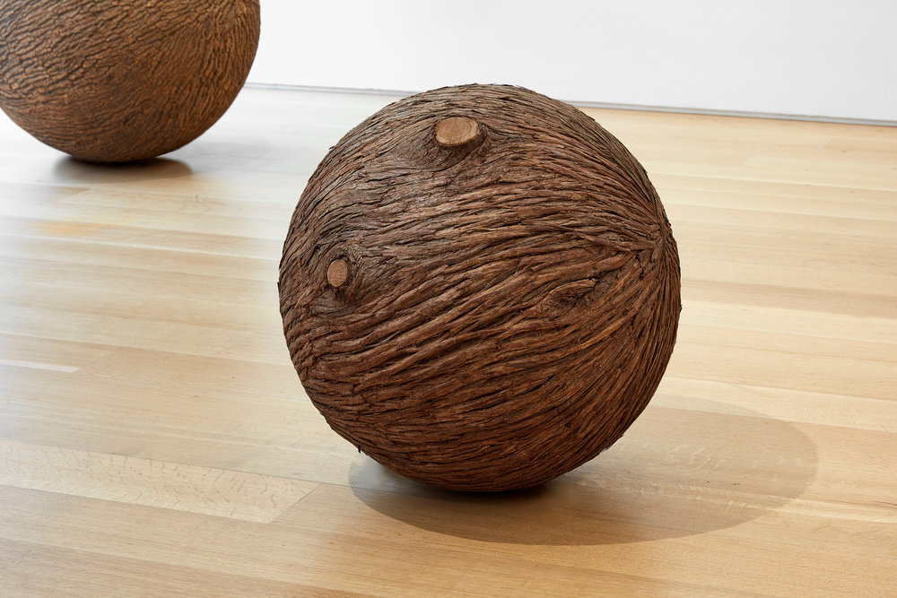 A spherical sculpture made of wood and bark that resembles a tree trunk by Lars Fisk. 
