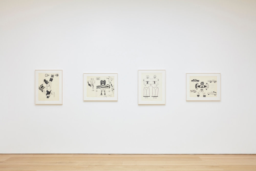 An installation view of four Karl Wirsum framed ink works on paper hanging on a wall horizontally. 