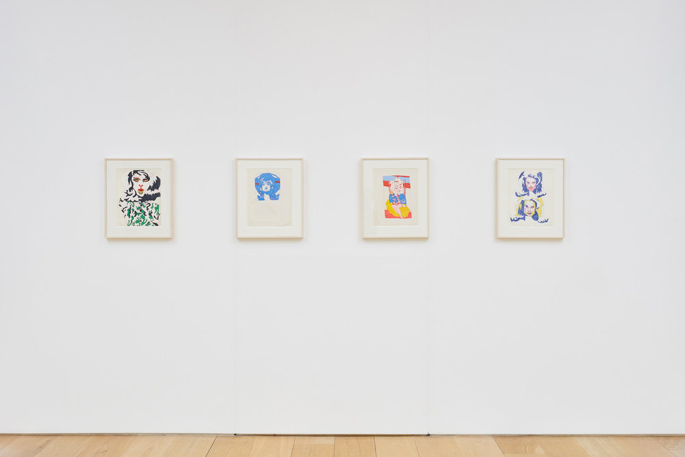 An installation view of four Karl Wirsum framed and color ink works on paper hanging on a wall horizontally. 