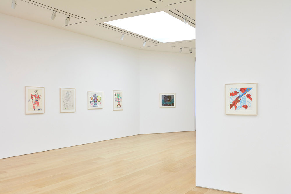 A partial view of five Karl Wirsum framed works on paper hanging in the gallery. 