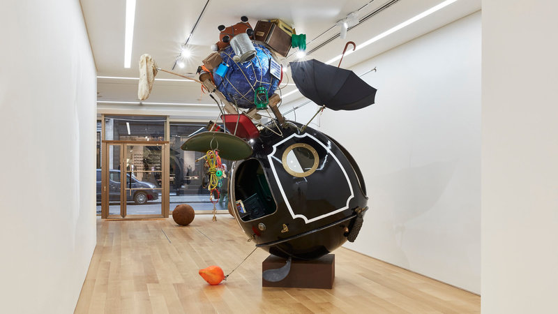 Spherical sculptures by Lars Fisk. In the foreground, a tiny home with a raggedy bunch of tools tacked on the side.  